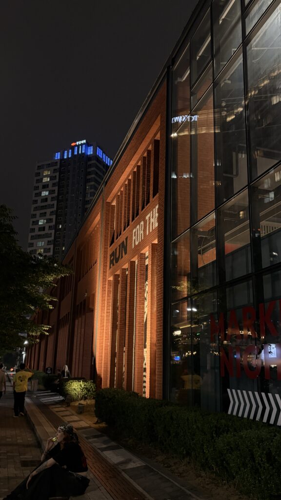 Exterior brick architecture and large entrance of Millac The Market at Night near the ocean