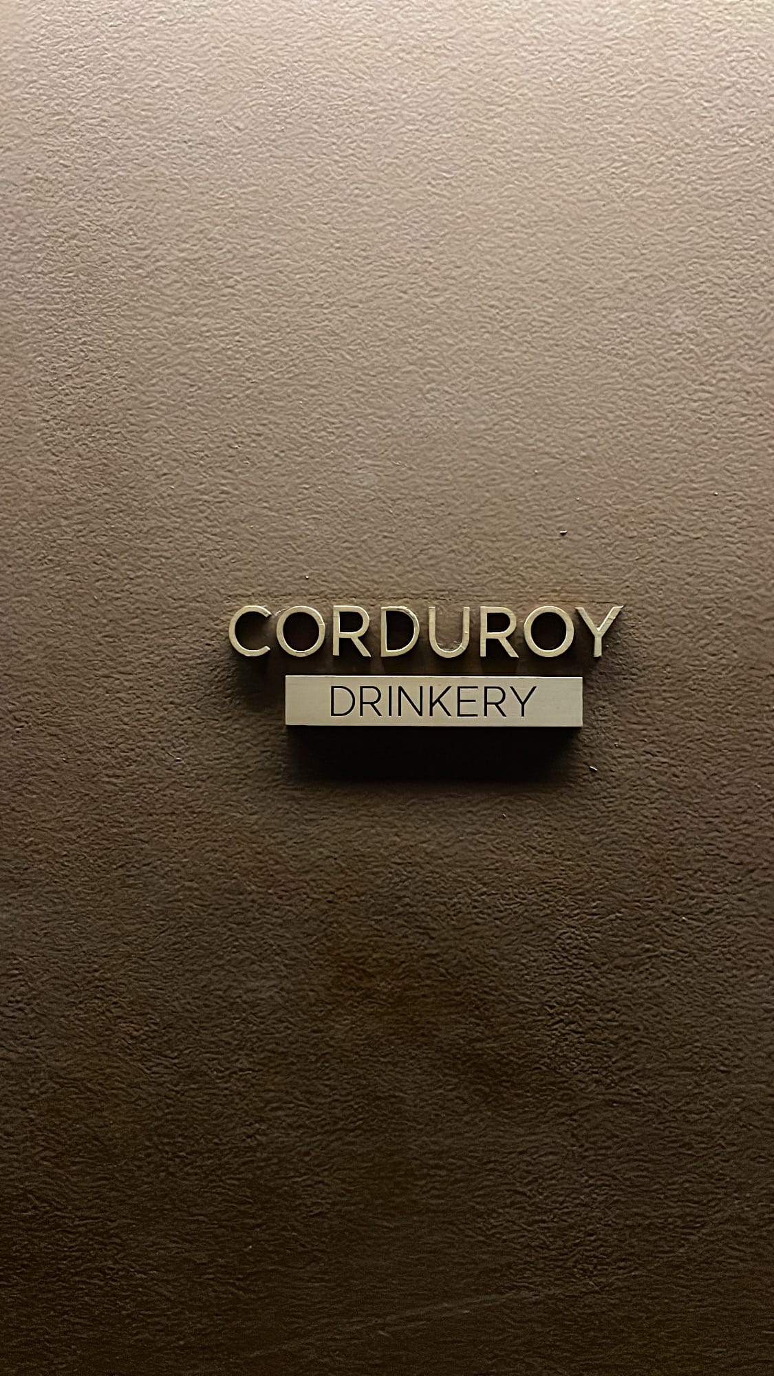 Small Corduroy Drinkery bronze signboard at the entrance