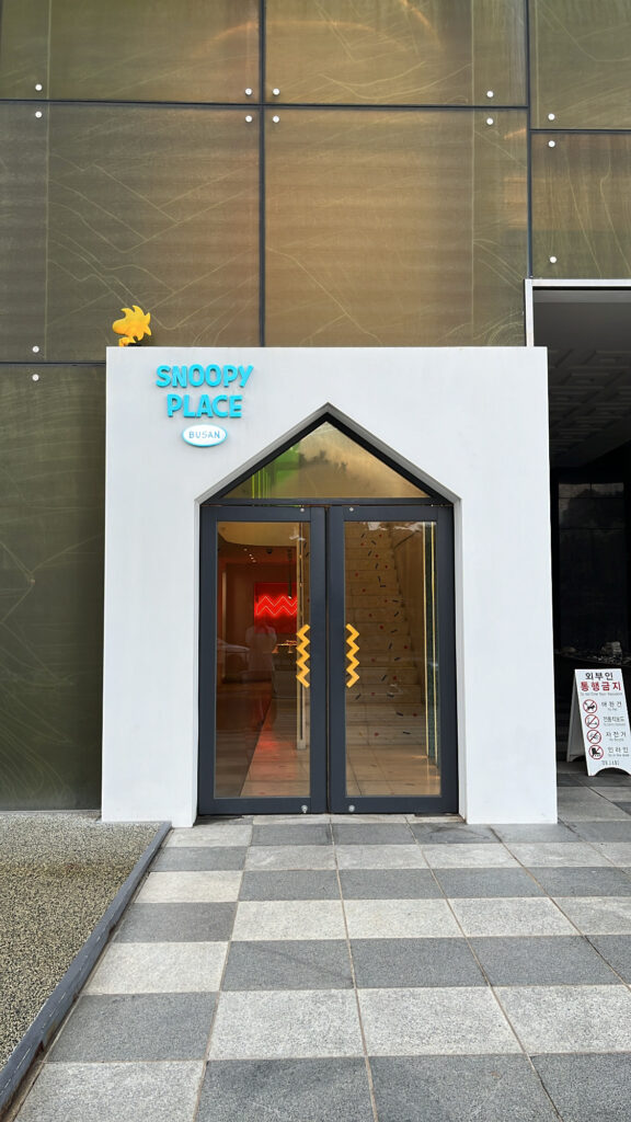 Cute house-shaped entrance of Snoopy Place Busan with Woodstock figure