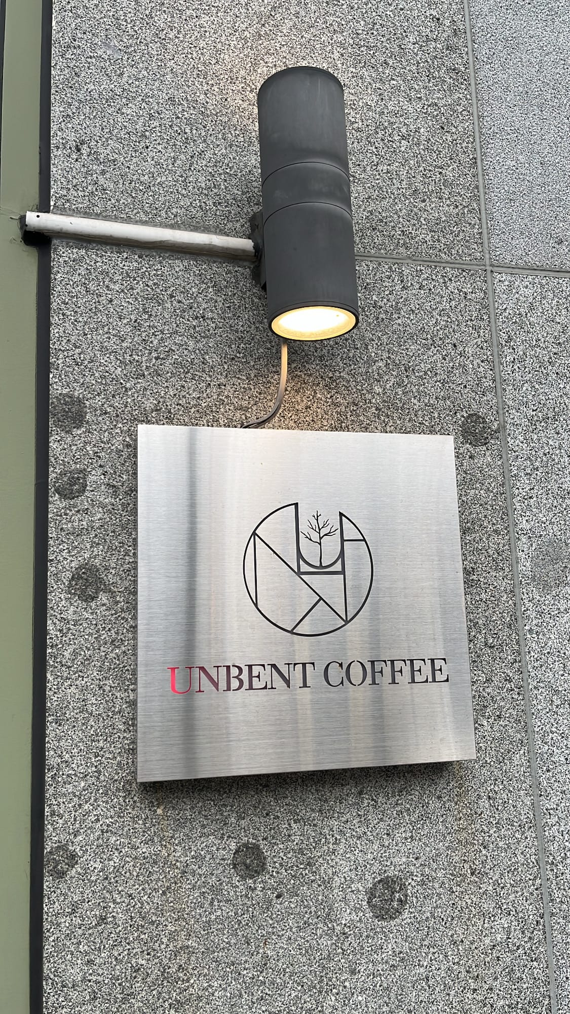 Stainless steel wall logo sign and lighting at Unbent Coffee Busan