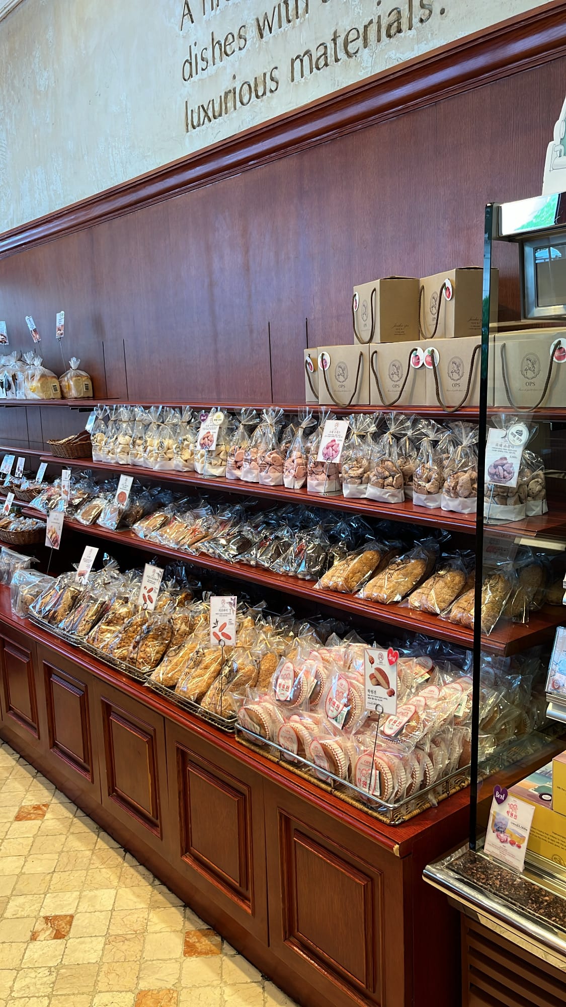 Packaged cookies, financiers, and pastries on wooden shelves at OPS