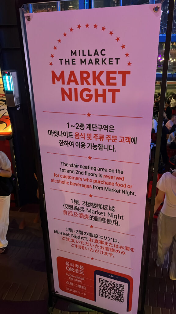 Market Night banner with multi-language rules and QR food ordering guide at Millac The Market at Night