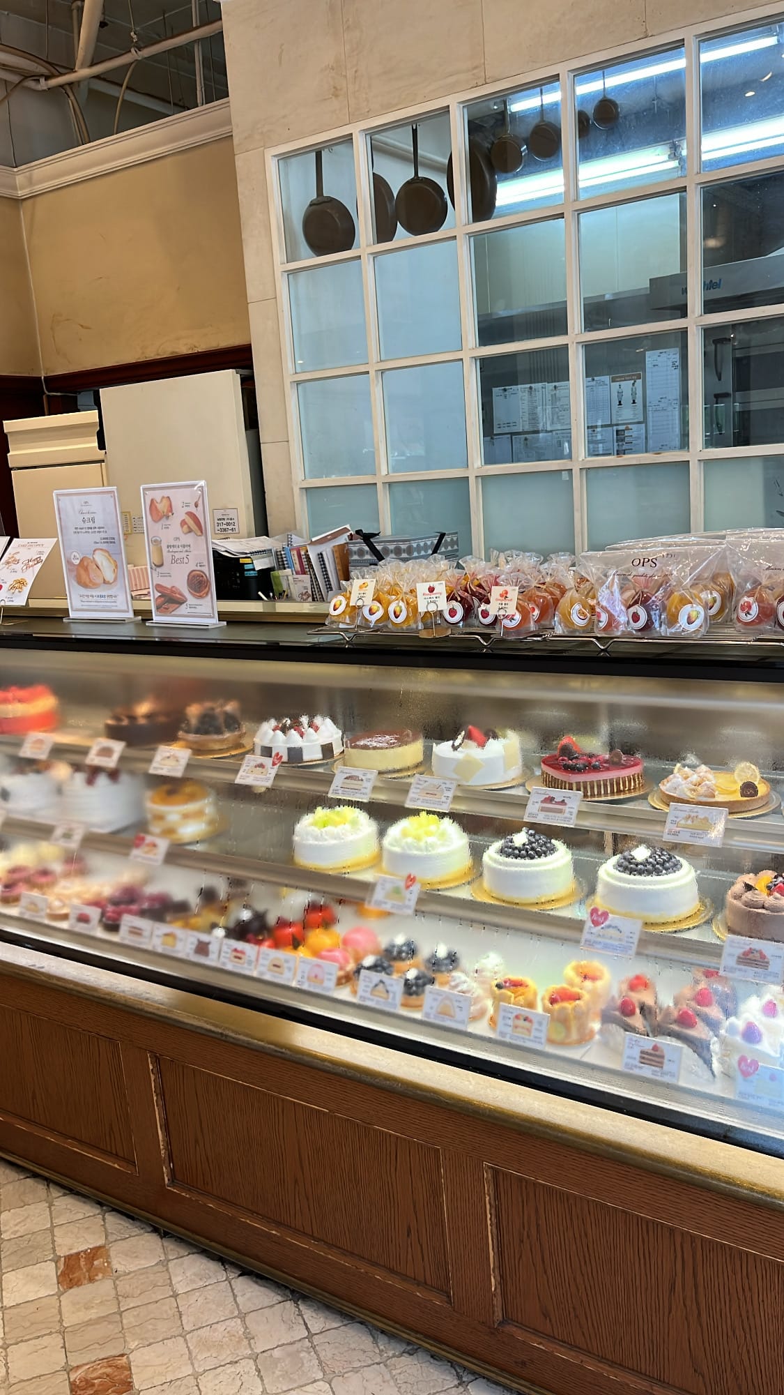 Refrigerated glass cake showcase with fruit cakes at OPS Bakery Busan