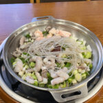 Fresh raw ingredients for Busan Nakgopsae at Gaemijip Songjeong featuring octopus, beef intestines, and shrimp