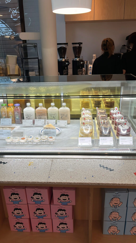 Showcase filled with Peanuts themed cakes and macarons at Snoopy Place Busan
