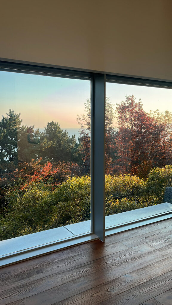 Autumn foliage and ocean view through large glass window at Johyun Gallery Busan