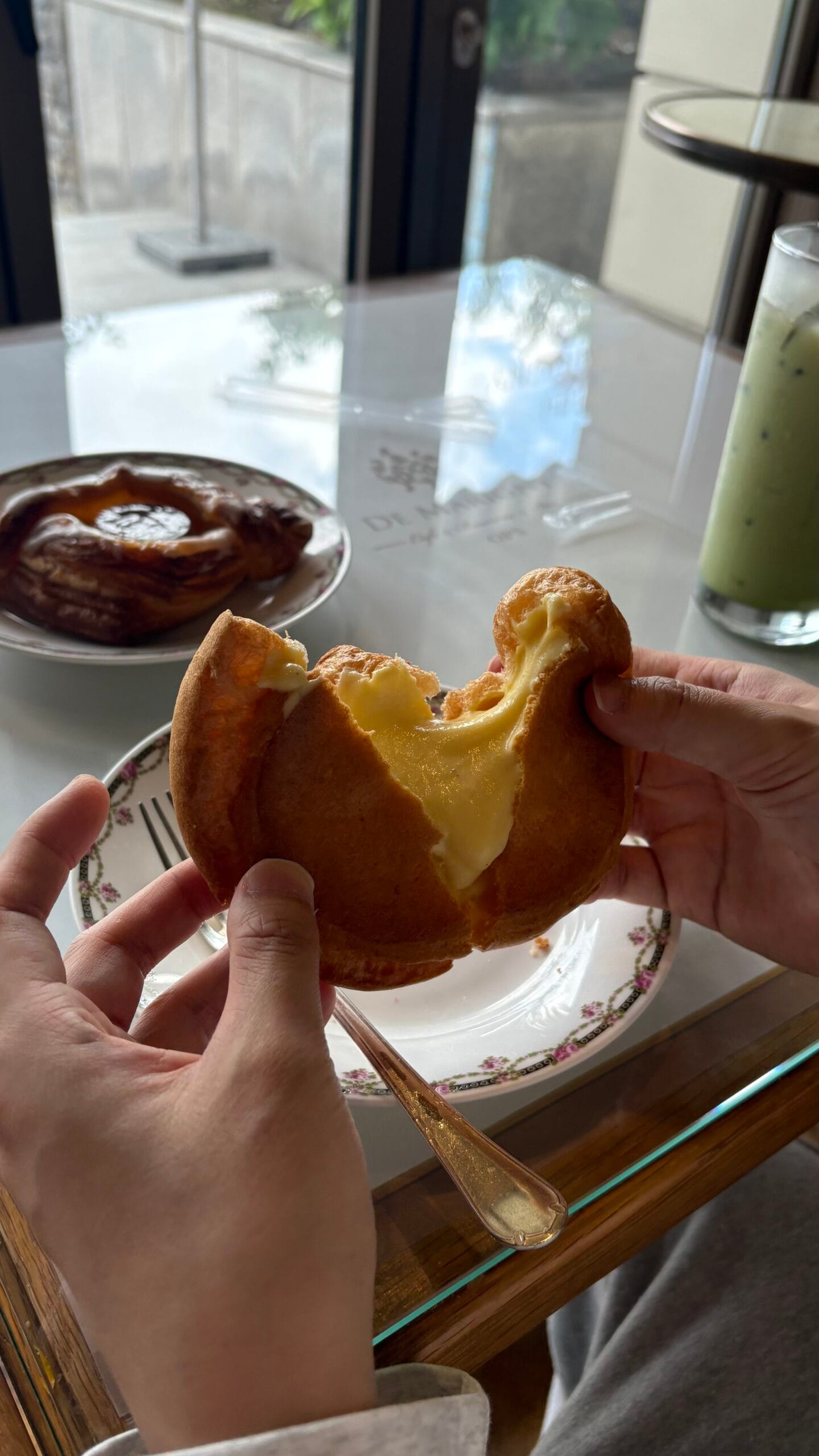 Breaking open signature OPS choux cream revealing thick vanilla custard