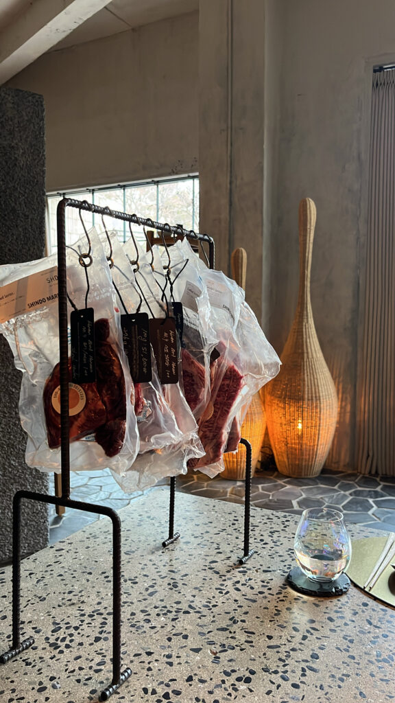 Hanging vacuum-sealed premium Hanwoo beef cuts on display at Moment Local Busan