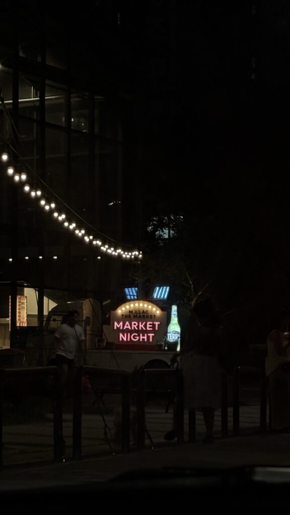Glowing Market Night sign board and string lights outside Millac The Market at Night