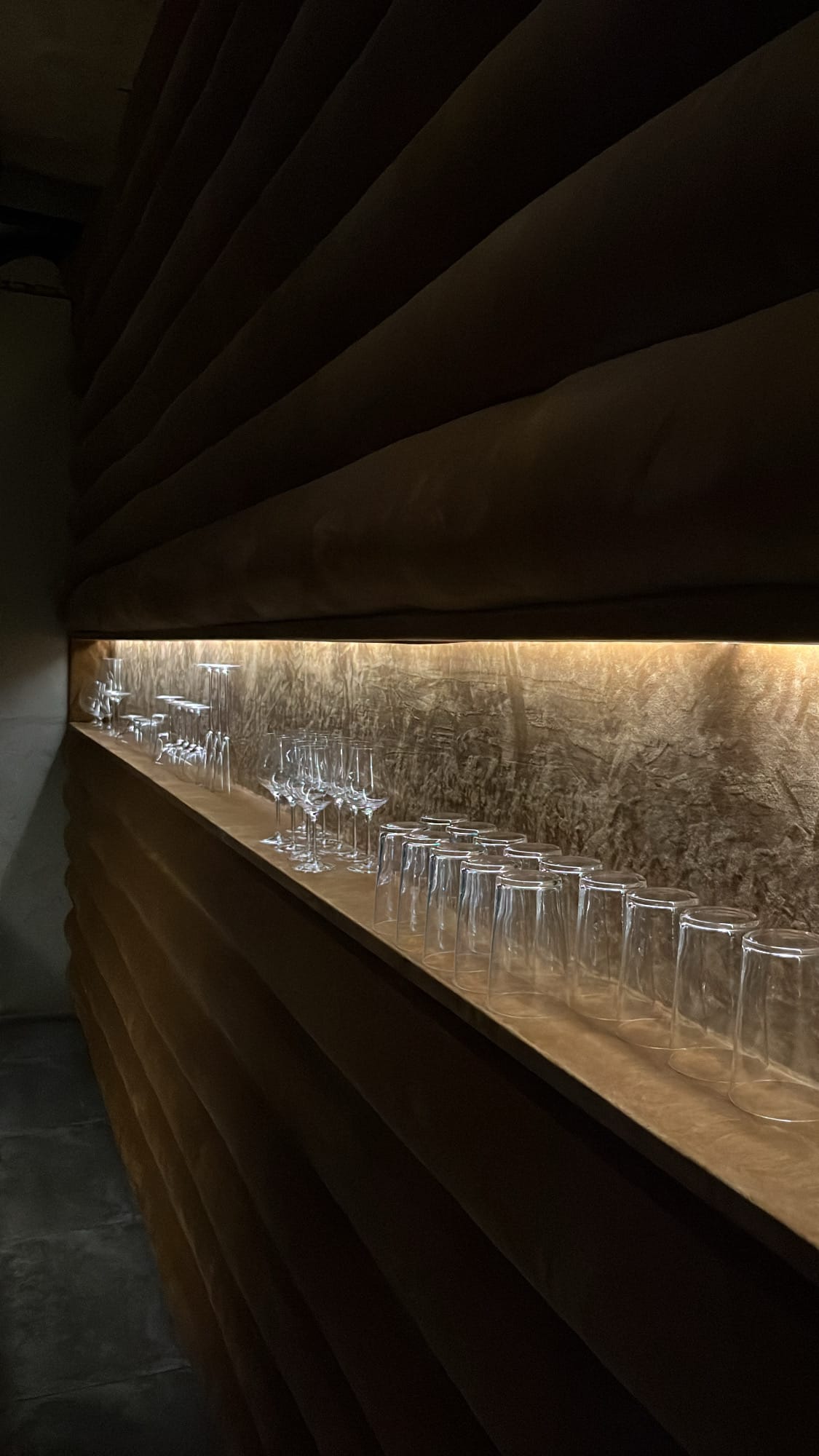 Long shelf displaying sparkling glassware inside private room area