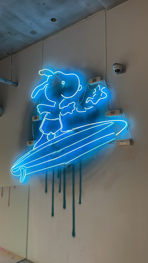 Glowing surfing Snoopy neon sign on the wall of 2nd floor at Snoopy Place Busan