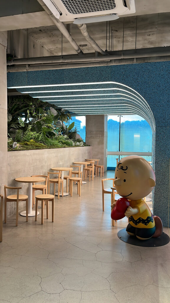 Cozy interior design with a Snoopy figure sitting near the table at Haeundae cafe