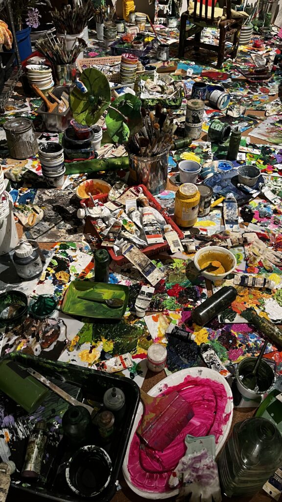 Detailed view of paint tubes, brushes, and art supplies in artist studio at Johyun Gallery Busan