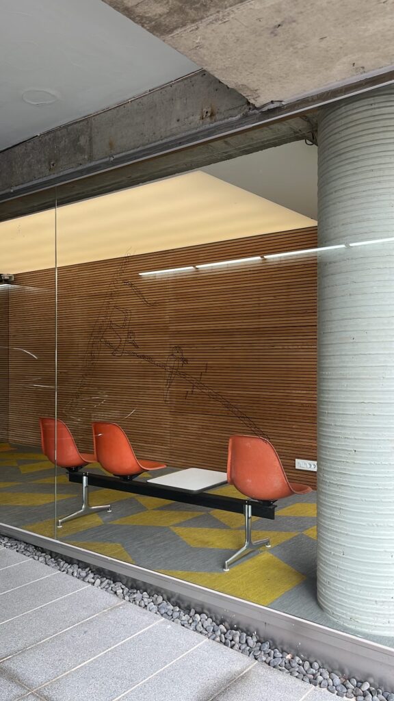 Orange chairs and glass partition interior of parking area at Johyun Gallery Busan