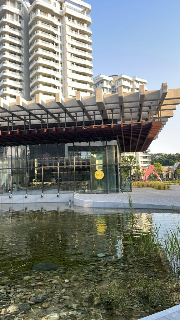 Exterior view of Sobae Busan with its reflective water pond and modern architecture in Gijang