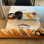 Table spread with B sushi set, crispy tempura, and cold soba at Songjeong Sushi Busan