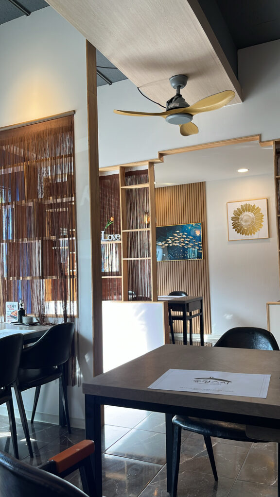 Cozy and well-organized interior dining hall with clean tables at Songjeong Sushi Busan