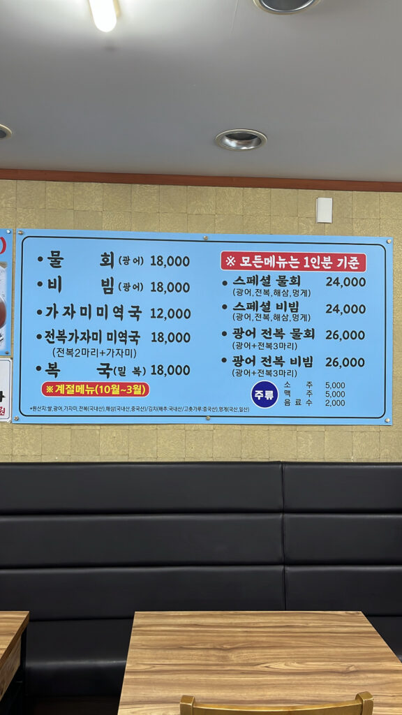 Menu board showcasing cold raw fish soup and flounder seaweed soup at Dongchon Mulhoe Busan