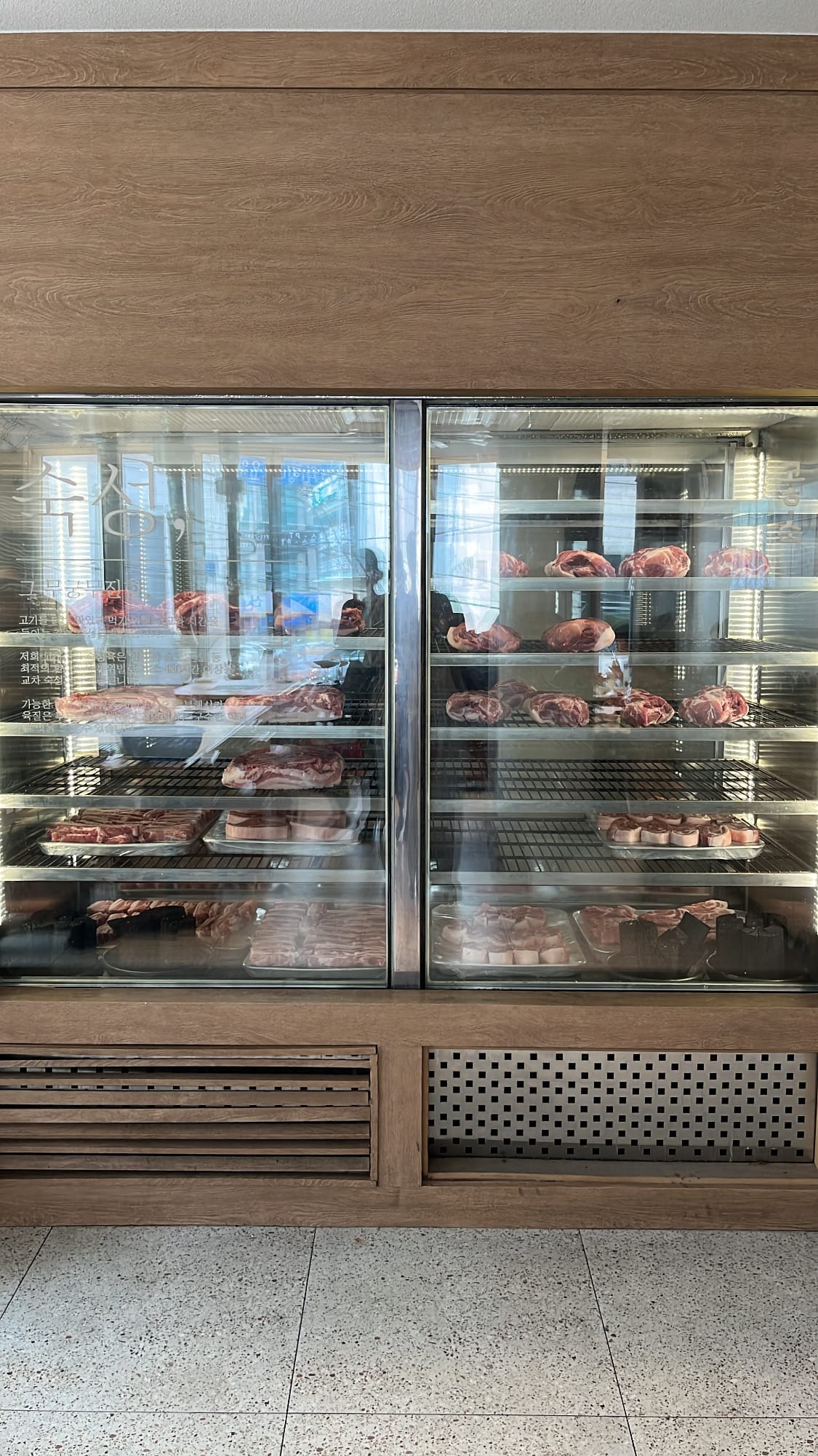 Glass meat aging showcase displaying premium pork cuts at Gohasoon Gwangalli