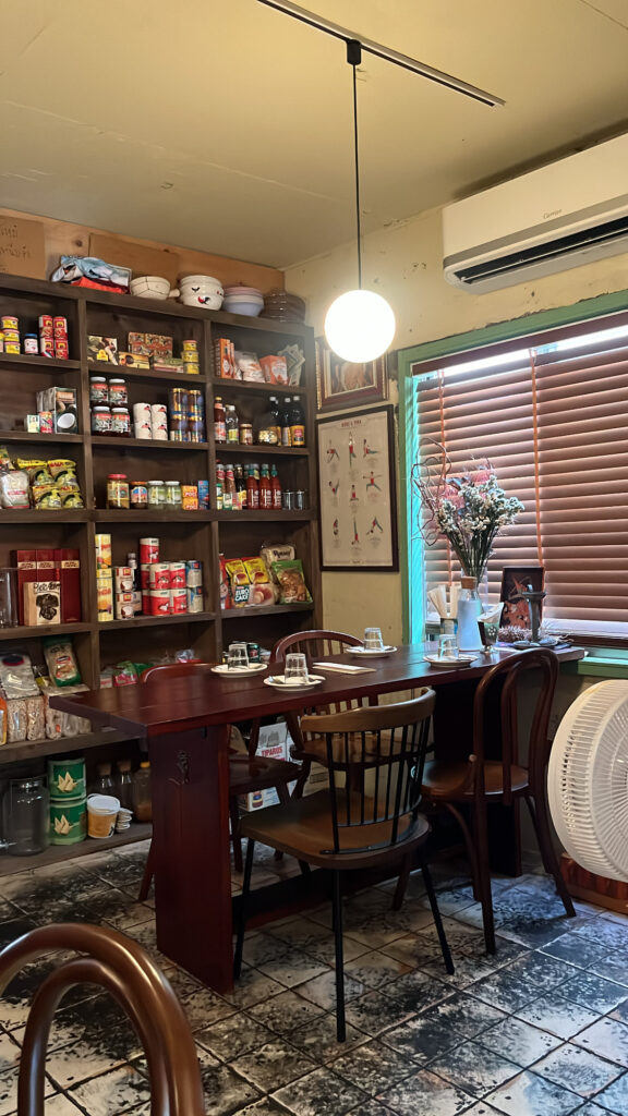 Comfortable dining table seating surrounded by Thai ingredient shelves at Pili Pili