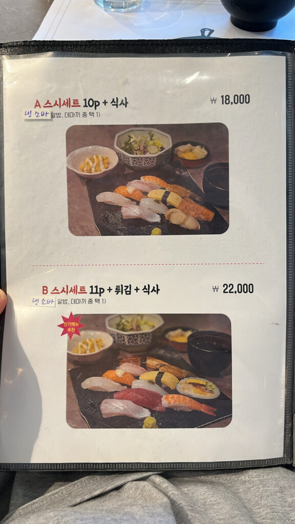 Restaurant menu page showing basic sushi sets A and B with meal options at Songjeong Sushi Busan