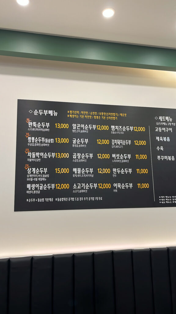Wall menu board at Wandduk Sundubu showing various spicy soft tofu stew options