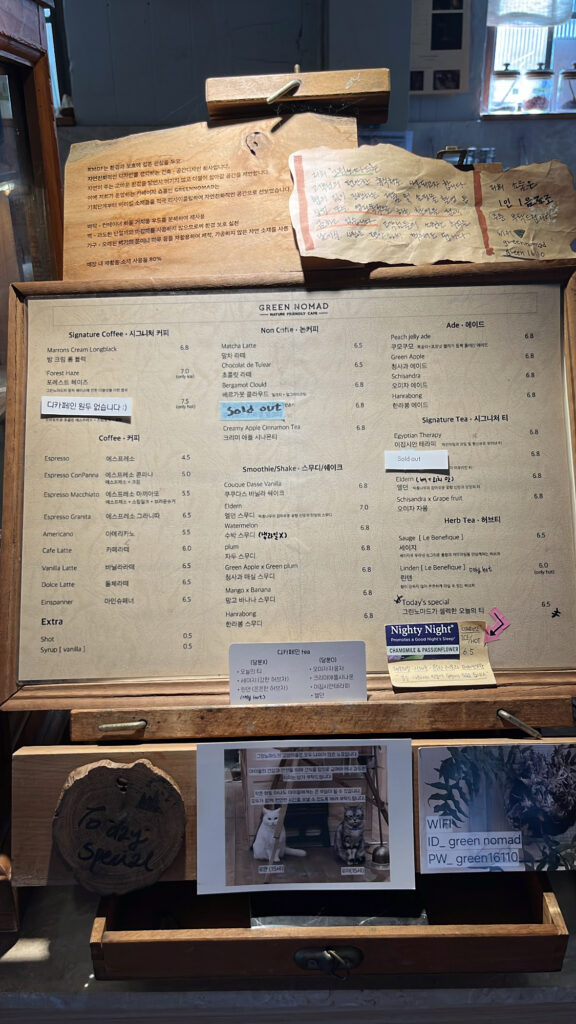 Full drink and dessert menu board placed at the counter of Green Nomad Busan cafe