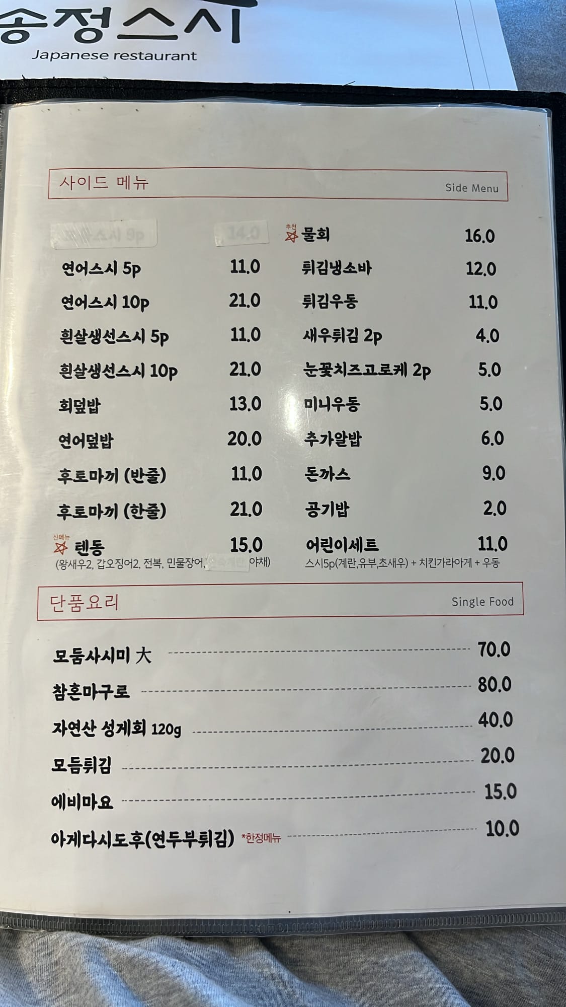 A la carte dishes, fresh seafood sides, and additional food menu board at Songjeong Sushi Busan