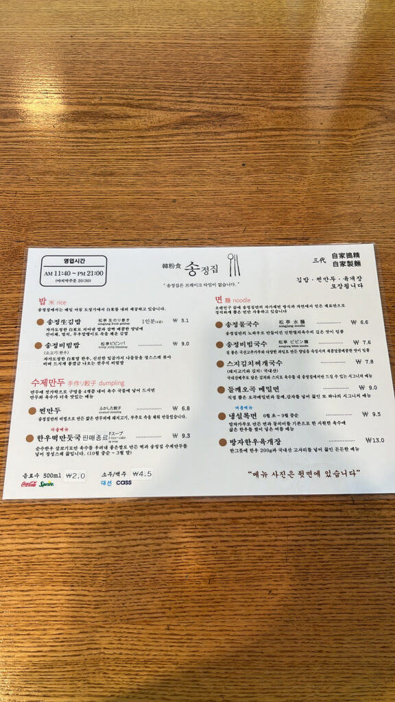 Paper menu listing available dishes on the table at Songjeongjib