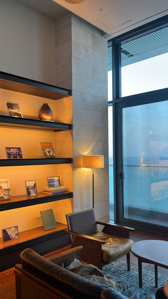 Cozy check-in waiting lounge and cafe interior with bookshelves at Ananti Cove