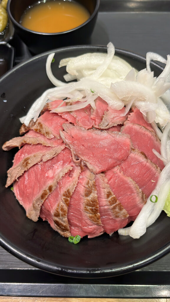 Close-up view of tender sliced steak and savory onion topping