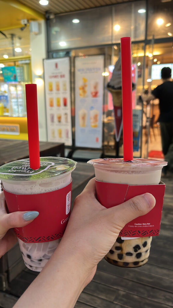 Holding Gong Cha Centum City Black Milk Tea and Taro Milk Tea with tapioca pearls