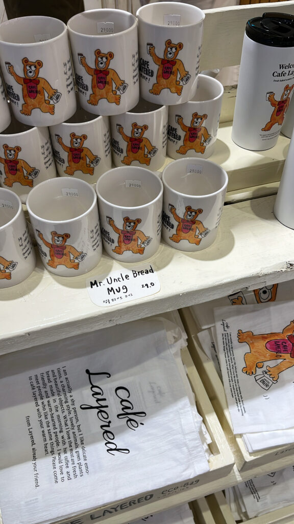 Branded coffee mugs available for purchase at Cafe Layered