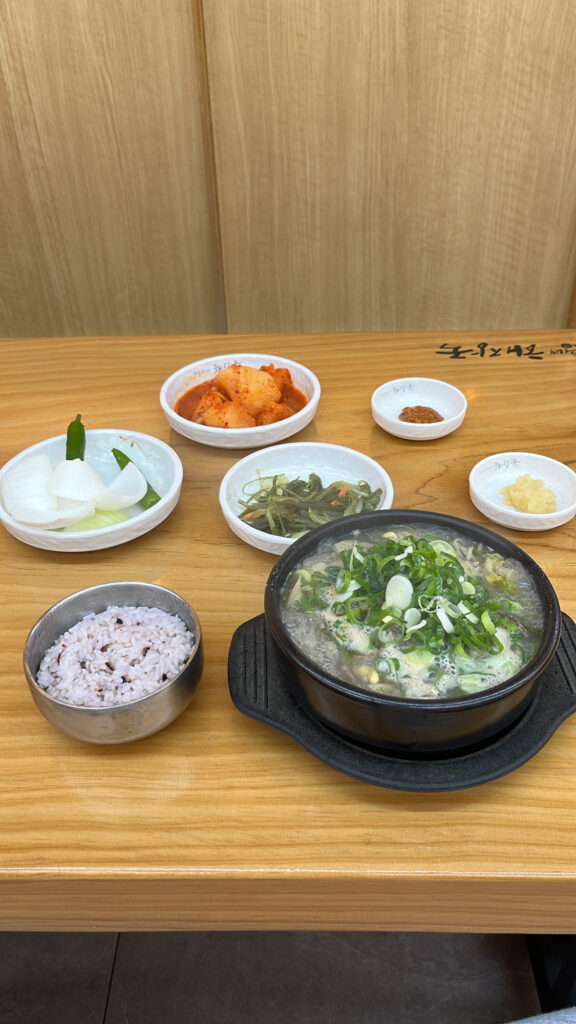 Complete meal table setting with Jeju style beef soup and side dishes in Busan