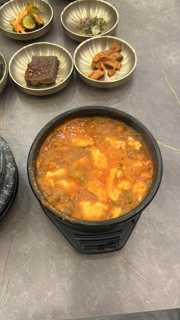 Hot and bubbling spicy soft tofu stew Busan style served in an earthenware bowl