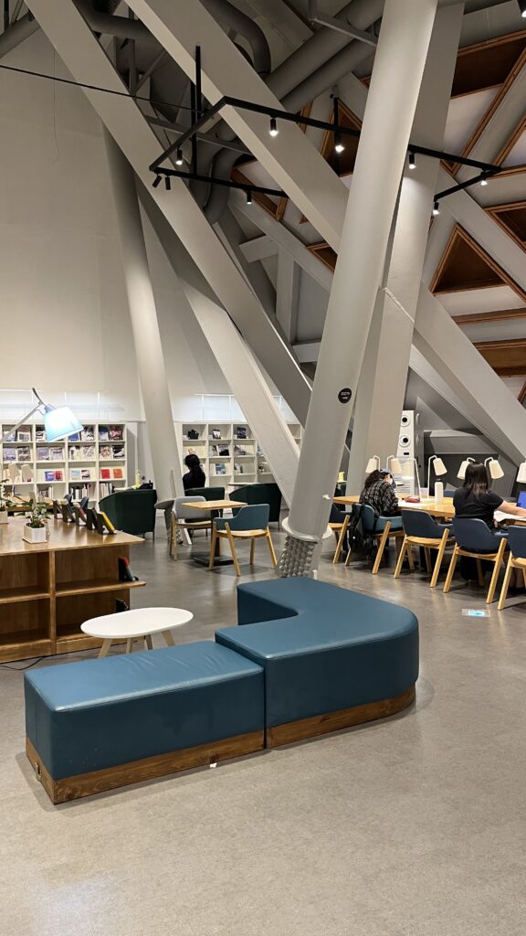 Comfortable lounge seating and geometric ceiling columns inside the library