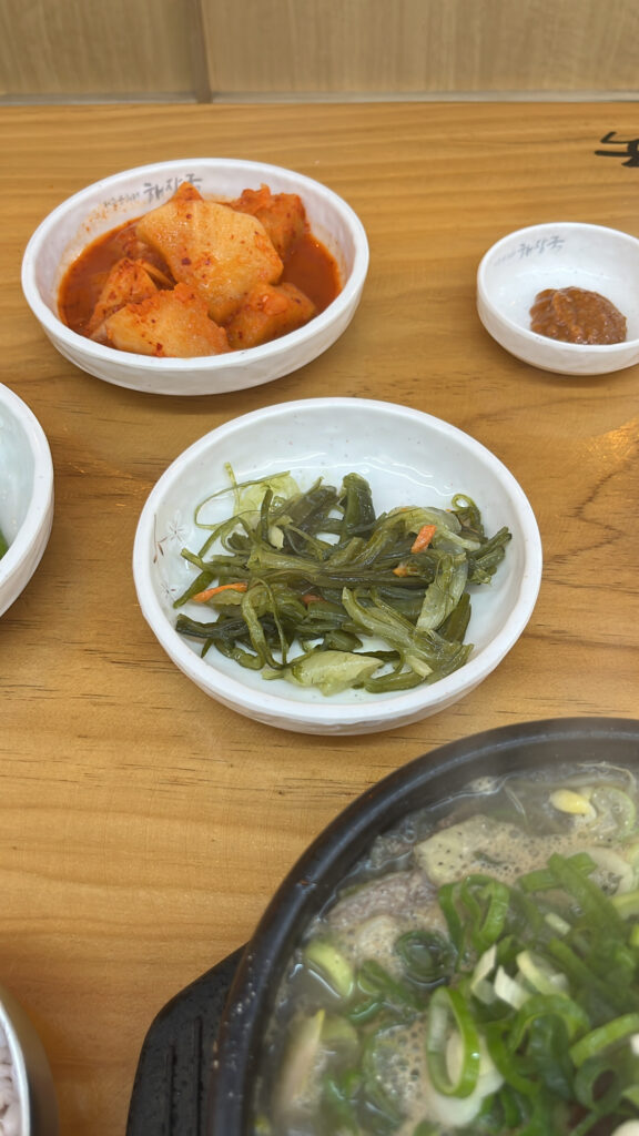 Side dishes including seasoned sea mustard stem served with beef soup