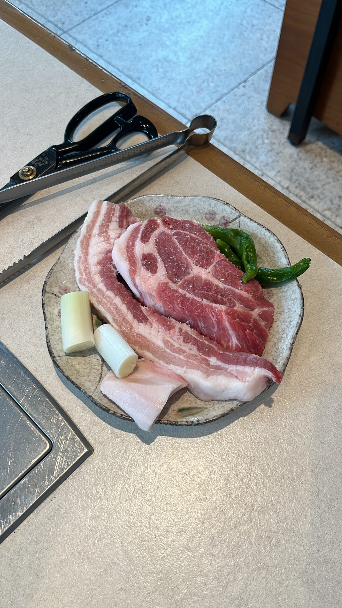 Top-down view of beautifully marbled raw aged pork served on a plate at Gohasoon