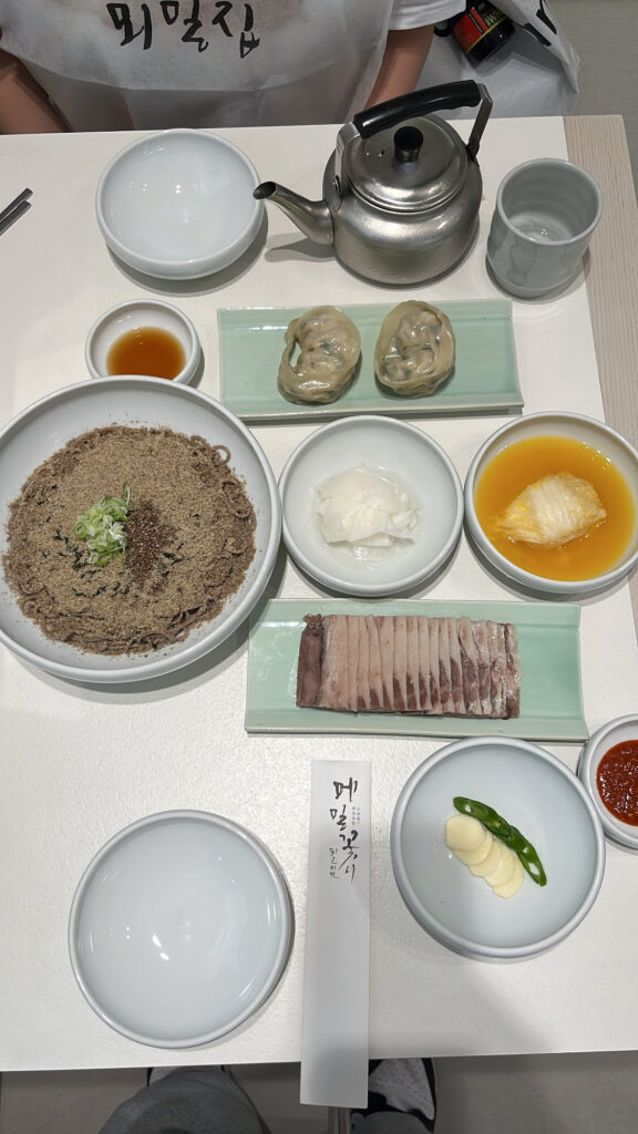 Top-down view of buckwheat noodles and side dishes at Moemiljip Busan