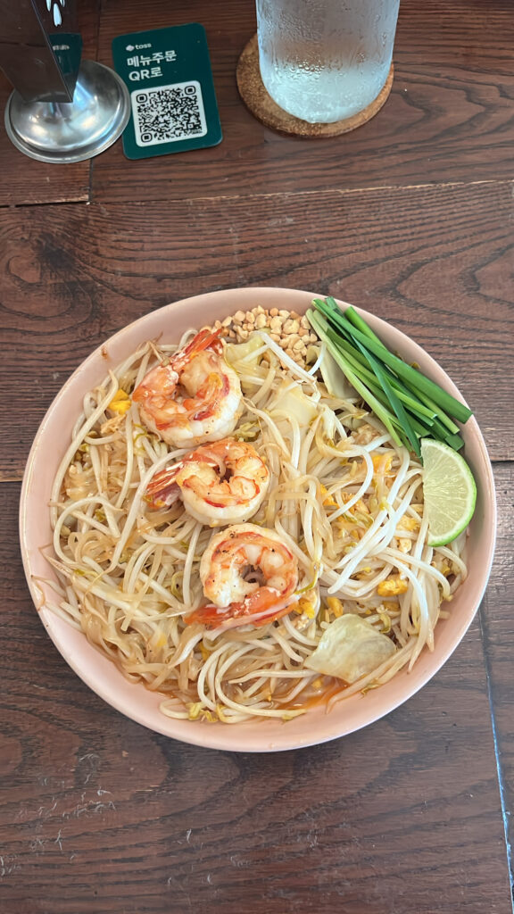 Close-up of authentic shrimp pad thai with bean sprouts and lime at Pili Pili Busan