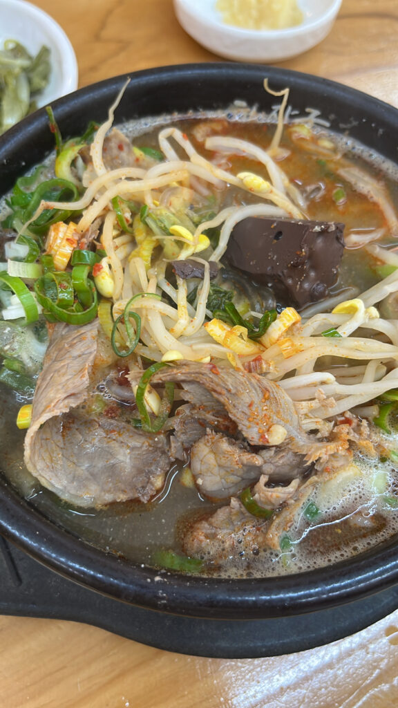 Closeup of Jeju style beef soup with red spicy paste and bean sprouts