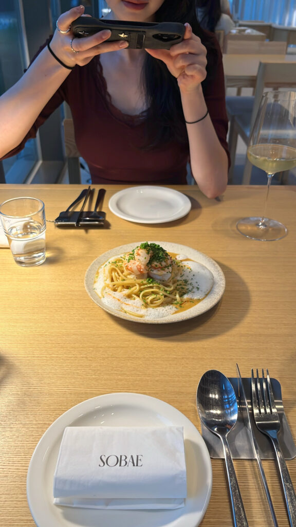 Table setting with Red Shrimp X.O Pasta paired with a glass of crisp Sauvignon Blanc at Sobae Busan