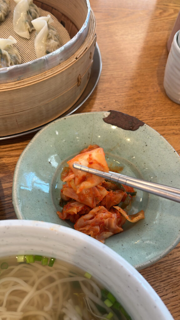 Spicy Korean kimchi side dish paired with noodles at Songjeongjib