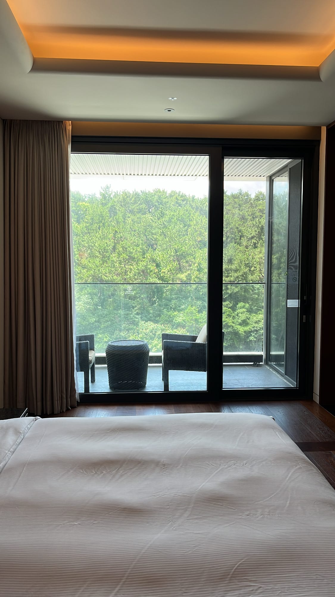 Asientos en un balcón privado, perfectos para tomar una copa de vino o un té mientras se disfruta de unas vistas panorámicas del bosque
