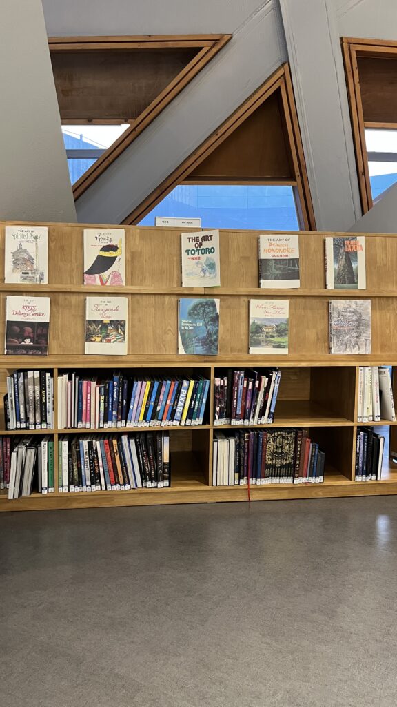Wooden bookshelves dedicated to animation art books and film photo collections