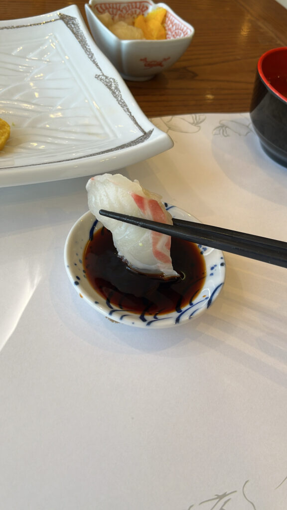 Dipping fresh fish sushi into soy sauce at Moon Sushi