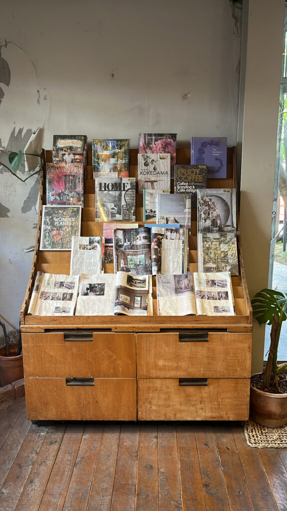 Gardening and landscape design books displayed on a vintage cabinet at Green Nomad Busan