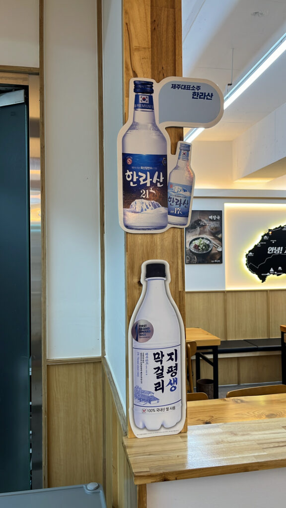 Traditional Korean rice wine Makgeolli bottle served with spicy beef soup
