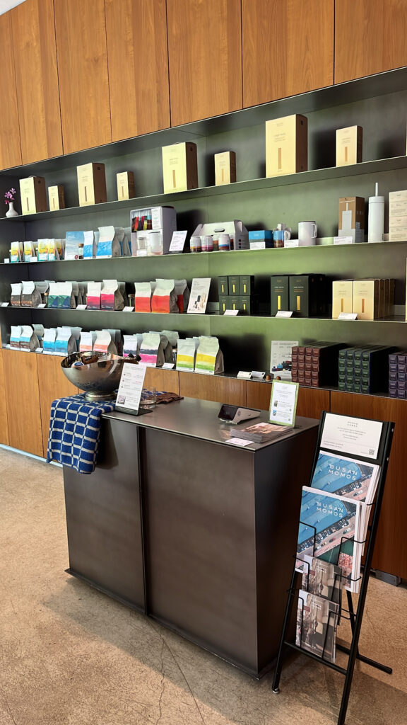 Retail shelf with whole bean coffee packages and tasting station at Momos Coffee Marine City