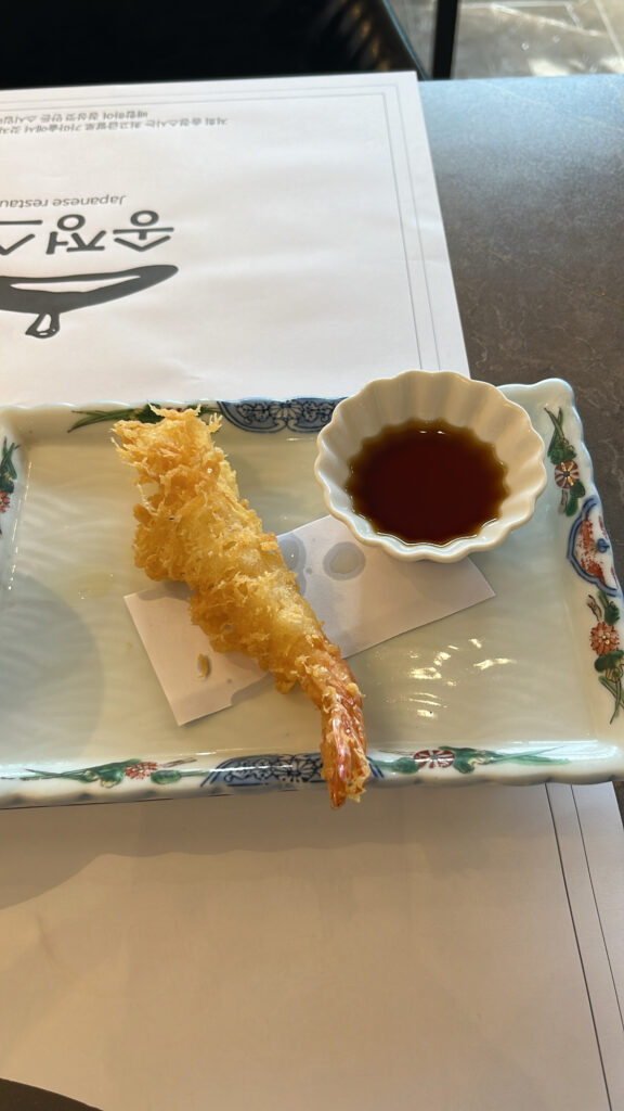 Crispy golden-fried shrimp tempura served with sweet dipping sauce at Songjeong Sushi Busan